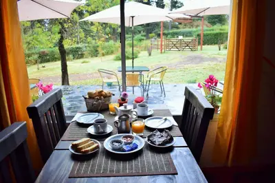 a wooden table with food on it with an umbrella at Posada Inguz in Villa Berna