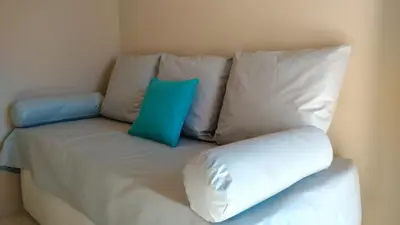 a couch with two blue pillows on top of it at Merlo Centro Aparts in Merlo