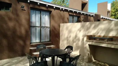 a table and chairs in front of a building at Merlo Centro Aparts in Merlo