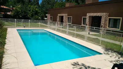 a large blue swimming pool next to a building at Merlo Centro Aparts in Merlo