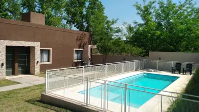 a swimming pool with a metal fence around it at Merlo Centro Aparts in Merlo