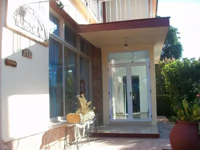 a house with a glass door on the side of it at Hotel Aoma Villa Carlos Paz in Villa Carlos Paz