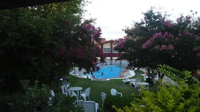 a view of a swimming pool with white chairs and tables at Hotel Aoma Villa Carlos Paz in Villa Carlos Paz