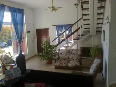 a living room with couches and a spiral staircase at Hotel Aoma Villa Carlos Paz in Villa Carlos Paz