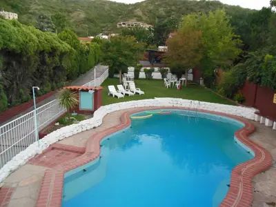 a large swimming pool in a yard with a fence at Hotel Aoma Villa Carlos Paz in Villa Carlos Paz