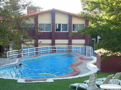 a swimming pool in front of a building at Hotel Aoma Villa Carlos Paz in Villa Carlos Paz