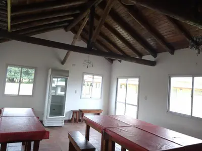 a room with wooden tables and chairs and windows at Cabañas Misky Wayra in San Francisco del Monte de Oro