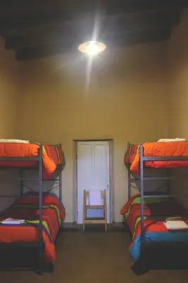 a room with three bunk beds and a window at al otro lado del río in San Francisco del Monte de Oro