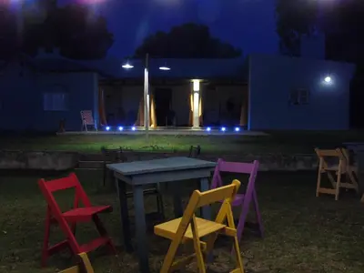 a group of chairs around a table at night at al otro lado del río in San Francisco del Monte de Oro