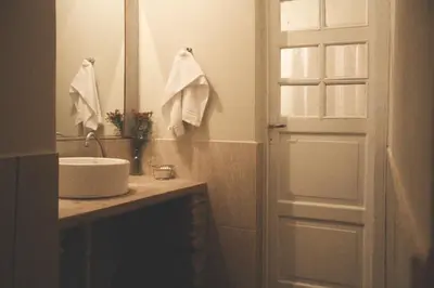 a bathroom with a sink and a mirror and a door at al otro lado del río in San Francisco del Monte de Oro