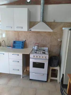a kitchen with a stove and a sink at Departamentos Calamuchita in Santa Rosa de Calamuchita
