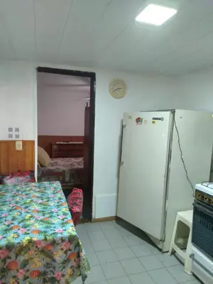 a room with a refrigerator and a bed in it at Departamentos Calamuchita in Santa Rosa de Calamuchita