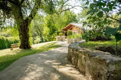 a stone path in front of a house with a tree at Del Arroyo Cabañas in Villa General Belgrano