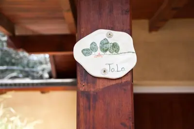 a plate with leaves on it on a wooden pole at Del Arroyo Cabañas in Villa General Belgrano