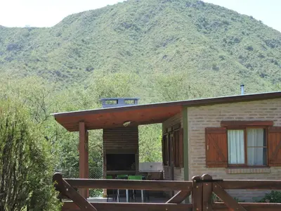 a house with a mountain in the background at CABAÑAS LOS COCKERS in Villa General Belgrano