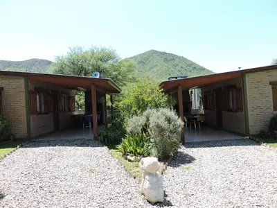 a building with a porch with a teddy bear in the yard at CABAÑAS LOS COCKERS in Villa General Belgrano