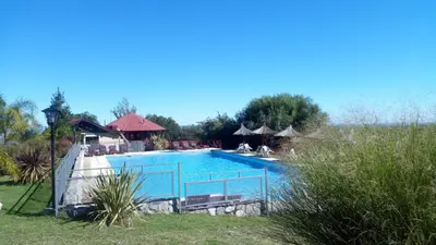 a large swimming pool with people sitting around it at Altos del Sol - Spa & Resort in Merlo