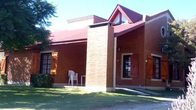a red brick house with a chair in the yard at Altos del Sol - Spa & Resort in Merlo