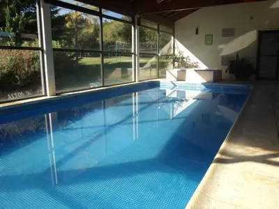 a large swimming pool in a house with windows at Altos del Sol - Spa & Resort in Merlo