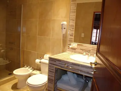 a bathroom with a toilet and a sink and a mirror at Altos del Sol - Spa & Resort in Merlo