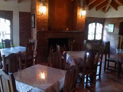 a dining room with tables and chairs and a fireplace at Dalmacia Petit Hotel in Nono