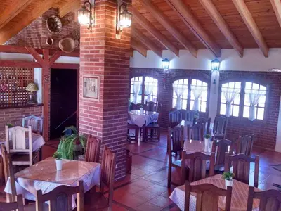 a restaurant with tables and chairs and a brick wall at Dalmacia Petit Hotel in Nono