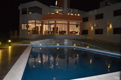 a swimming pool in front of a house at night at Complejo Riro Namaste in San Antonio de Arredondo