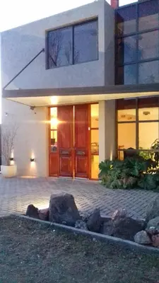 a house with a front entrance with rocks in front at Complejo Riro Namaste in San Antonio de Arredondo
