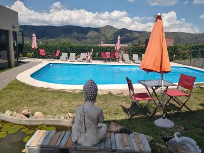 a statue sitting on a bench next to a swimming pool at Complejo Riro Namaste in San Antonio de Arredondo