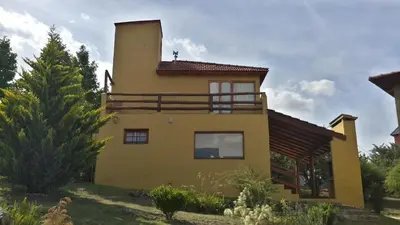 a yellow house with a tower on top of it at Cabañas Wairoa Haus in Villa General Belgrano