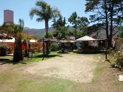 a park with trees and a building and a palm tree at Hotel Bialet Massé in Bialet Massé