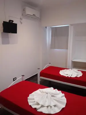 a room with two beds with red sheets at Hotel Bialet Massé in Bialet Massé