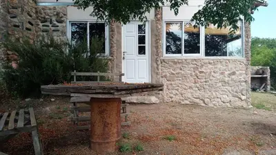a stone house with a bench in front of it at Cabañas La Rústica in Bialet Massé