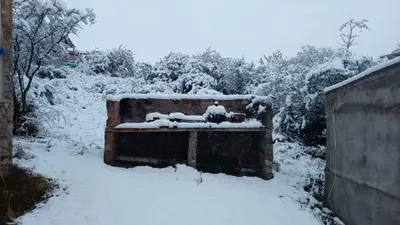 a bench covered in snow in a yard at Cabañas La Rústica in Bialet Massé