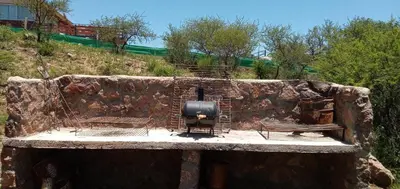 a stone wall with a stove and a bench at Cabañas La Rústica in Bialet Massé