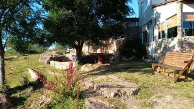 a wooden bench sitting in a yard next to a house at Cabañas La Rústica in Bialet Massé