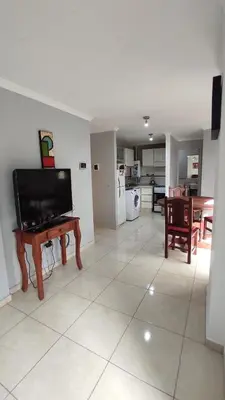 a living room with a flat screen tv and a table at Apartamento Allegro in Cordoba