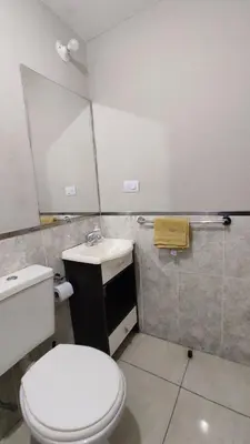 a bathroom with a white toilet and a sink at Apartamento Allegro in Cordoba