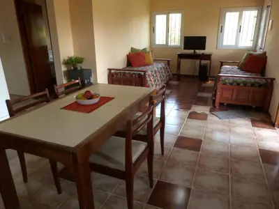 a living room with a table and chairs and a couch at El Pinar - Hospedaje Serrano in Tanti