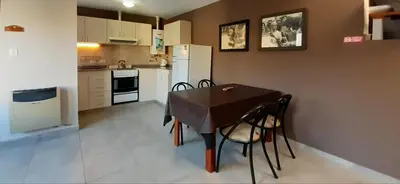 a small kitchen with a table and chairs in it at LA FOGLIA departamentos in Villa Carlos Paz