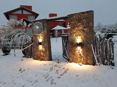 a house in the snow with lights on it at Punta Piedra cabañas & suites in Los Reartes
