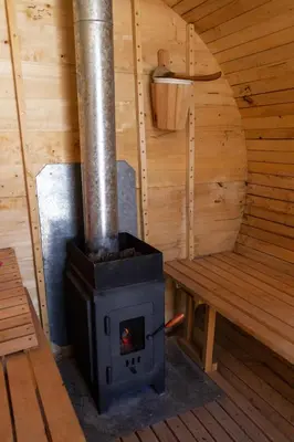 a wood stove in a cabin with a bench at Punta Piedra cabañas & suites in Los Reartes