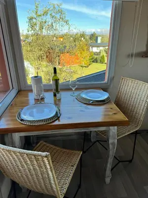 a dining table with two chairs and a window at Punta Piedra cabañas & suites in Los Reartes
