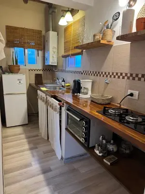 a kitchen with a sink and a stove top oven at Punta Piedra cabañas & suites in Los Reartes