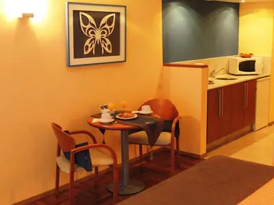 a small kitchen with a table and chairs in a room at King David Flat Hotel - Argentina in Cordoba