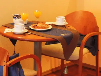 a table with a plate of food and two glasses of orange juice at King David Flat Hotel - Argentina in Cordoba