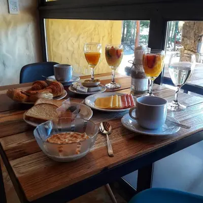 a wooden table with food and drinks on it at Posada Alma del Arroyo & Spa in Villa General Belgrano
