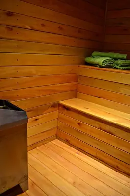 a wooden sauna with two steps and a green towel at Posada Alma del Arroyo & Spa in Villa General Belgrano