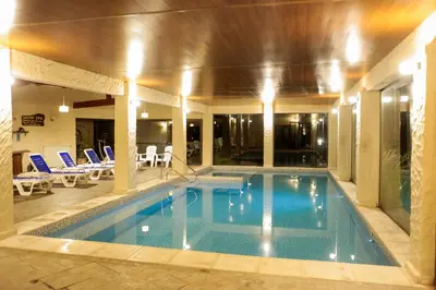 a large swimming pool in a building with a pool at Posada Alma del Arroyo & Spa in Villa General Belgrano