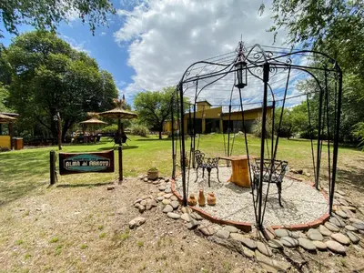 a playground with two chairs and a swing set at Posada Alma del Arroyo & Spa in Villa General Belgrano